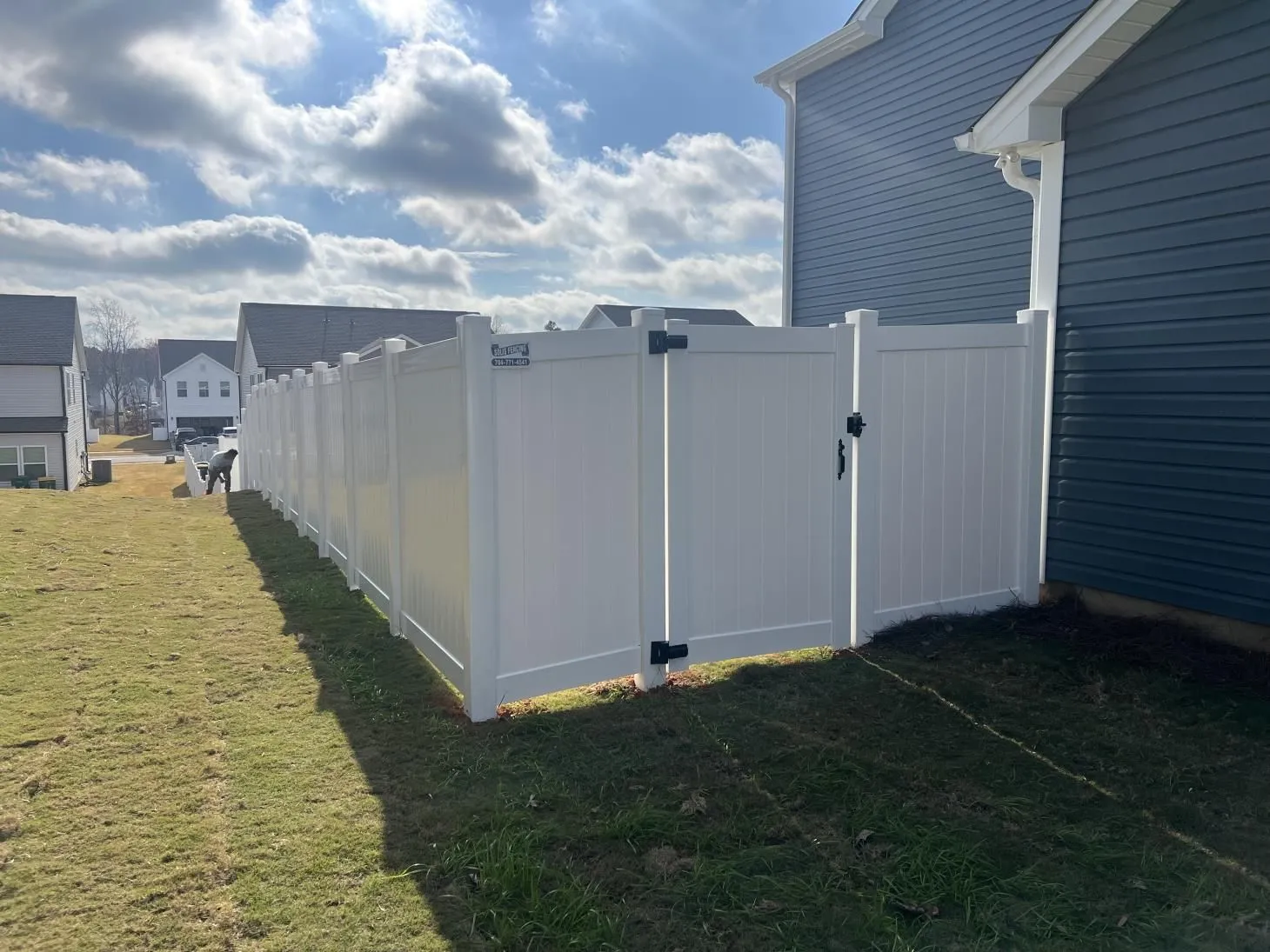 White vinyl fence beside a suburban house.