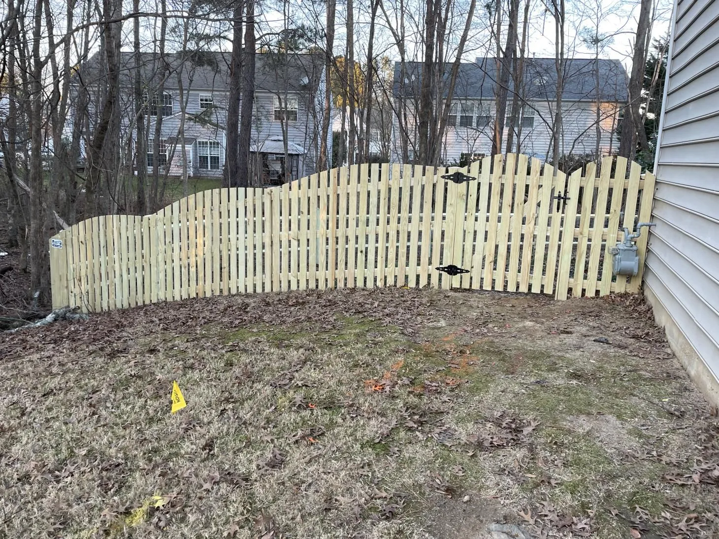 Wooden fence in suburban backyard with trees.