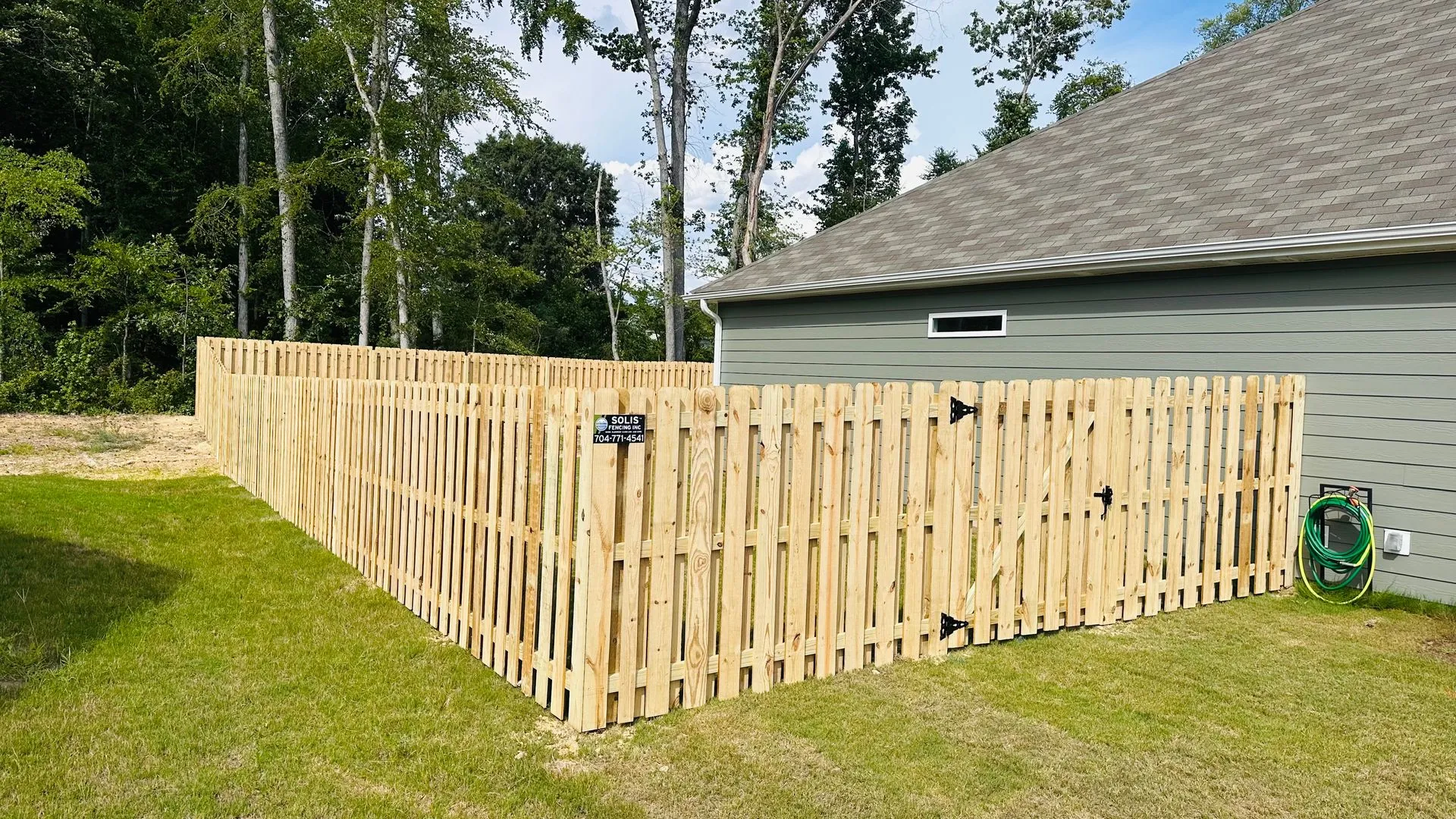 Wooden fence around a garden and house.