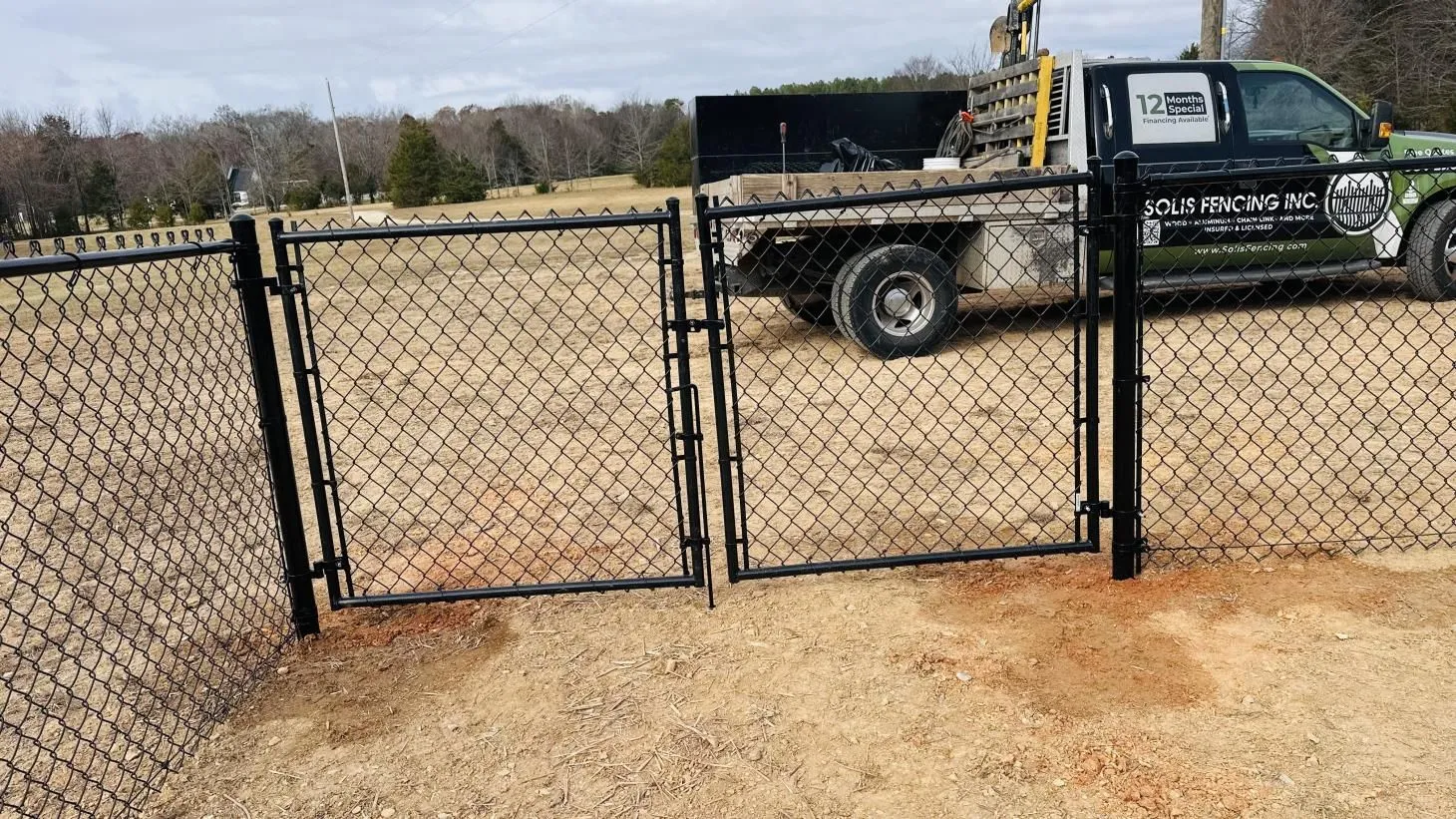 Chain-link fence with truck in background.