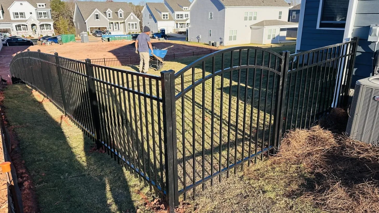 Black metal fence around grassy yard area.