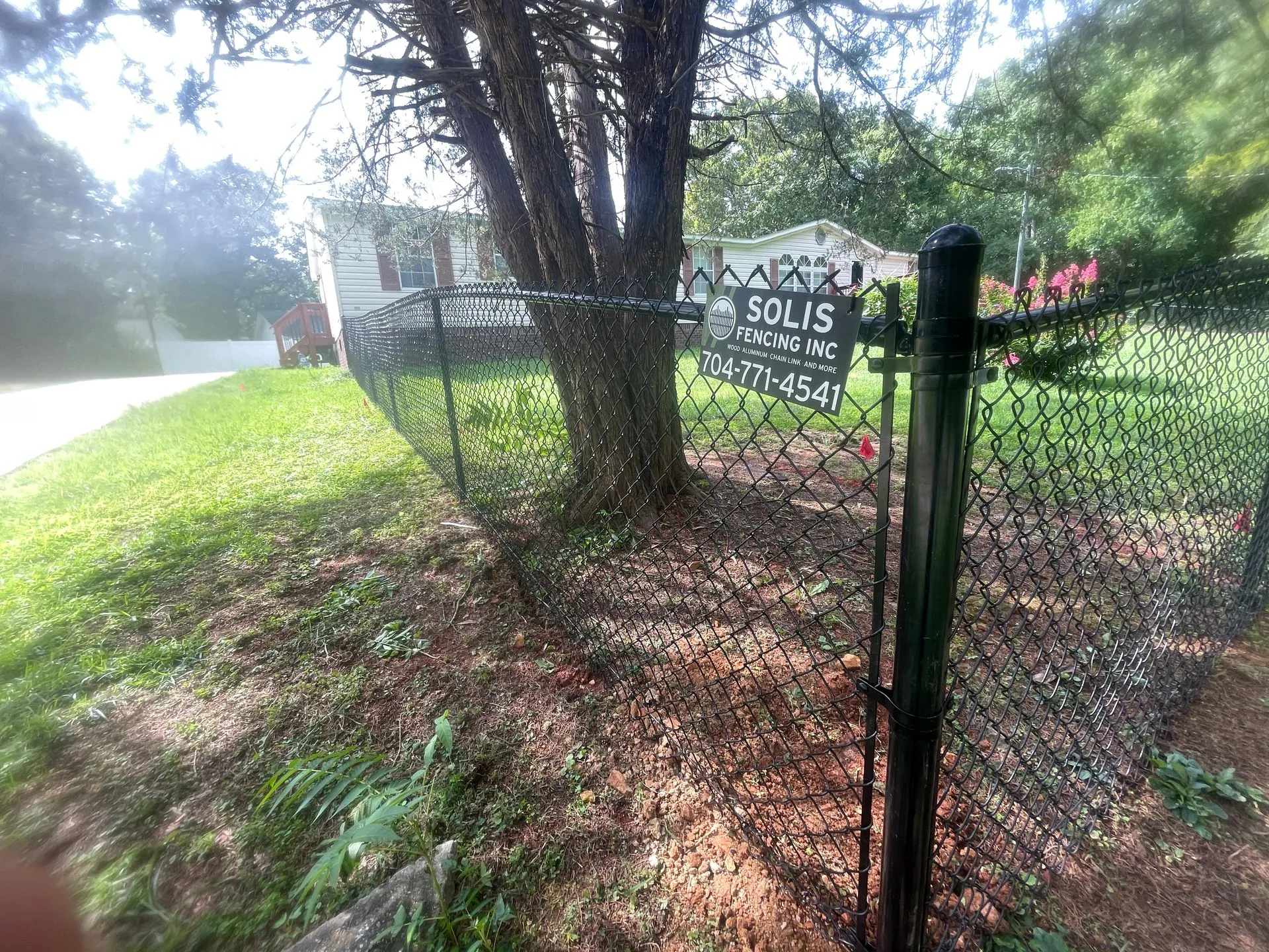 Chain link fence with company sign attached.