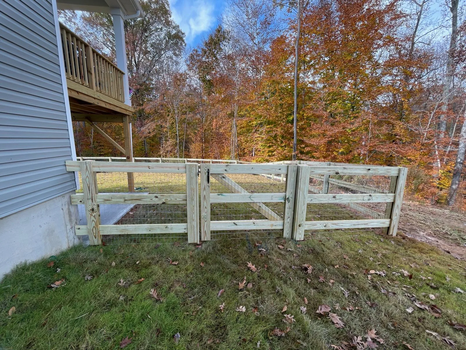 Wooden fence beside a house in autumn.