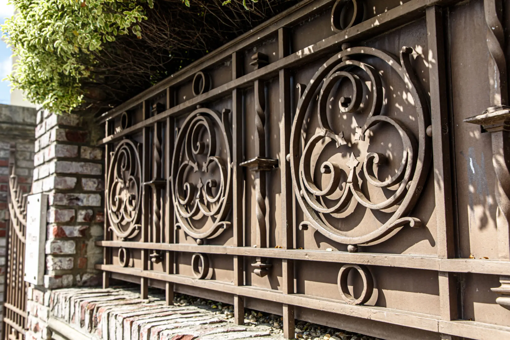 Ornate brown metal fence with circular scrollwork