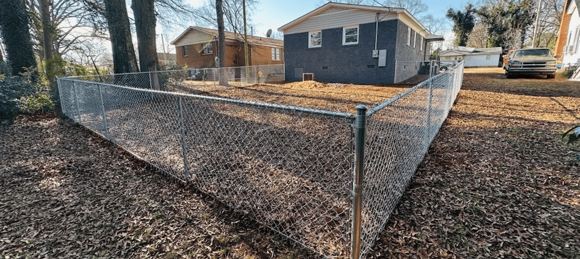 Chain-link fence surrounding a backyard area.