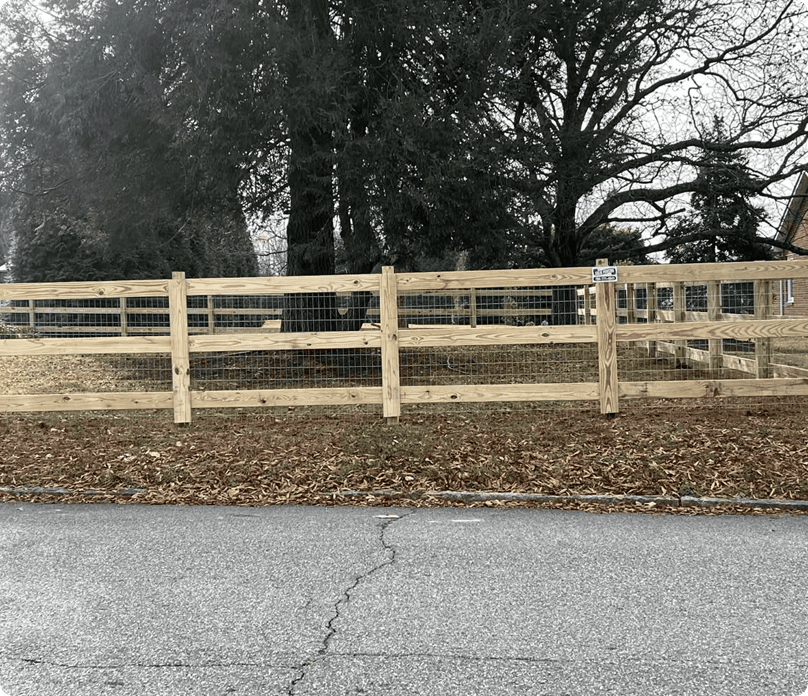 Wooden fence with trees in background.