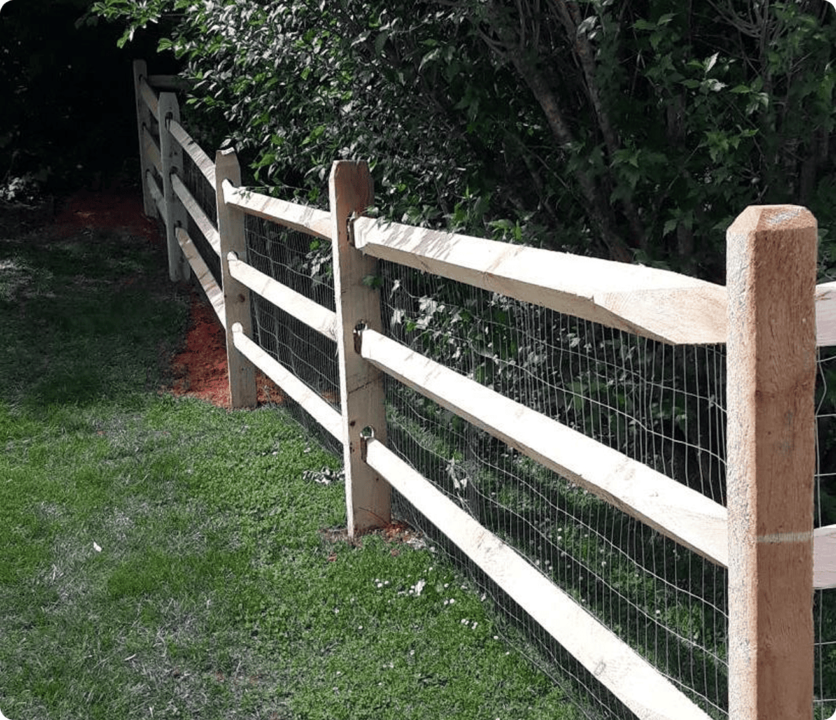 Wooden fence along green grassy area.