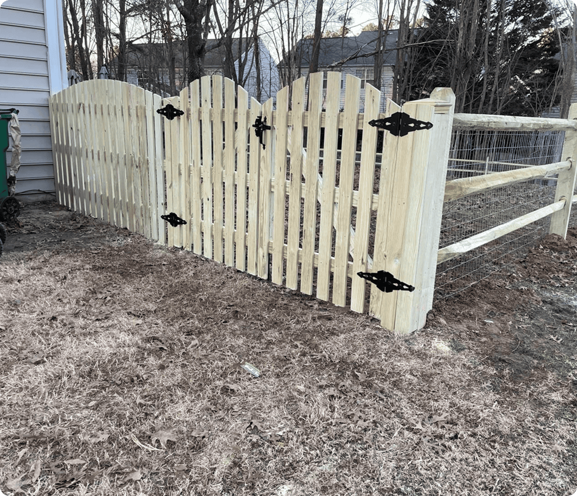 Wooden fence gate with black hinges.