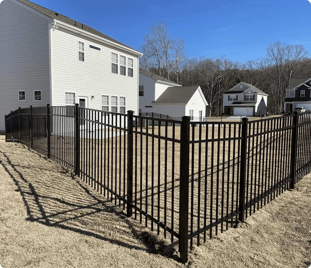 Black metal fence around suburban backyard.