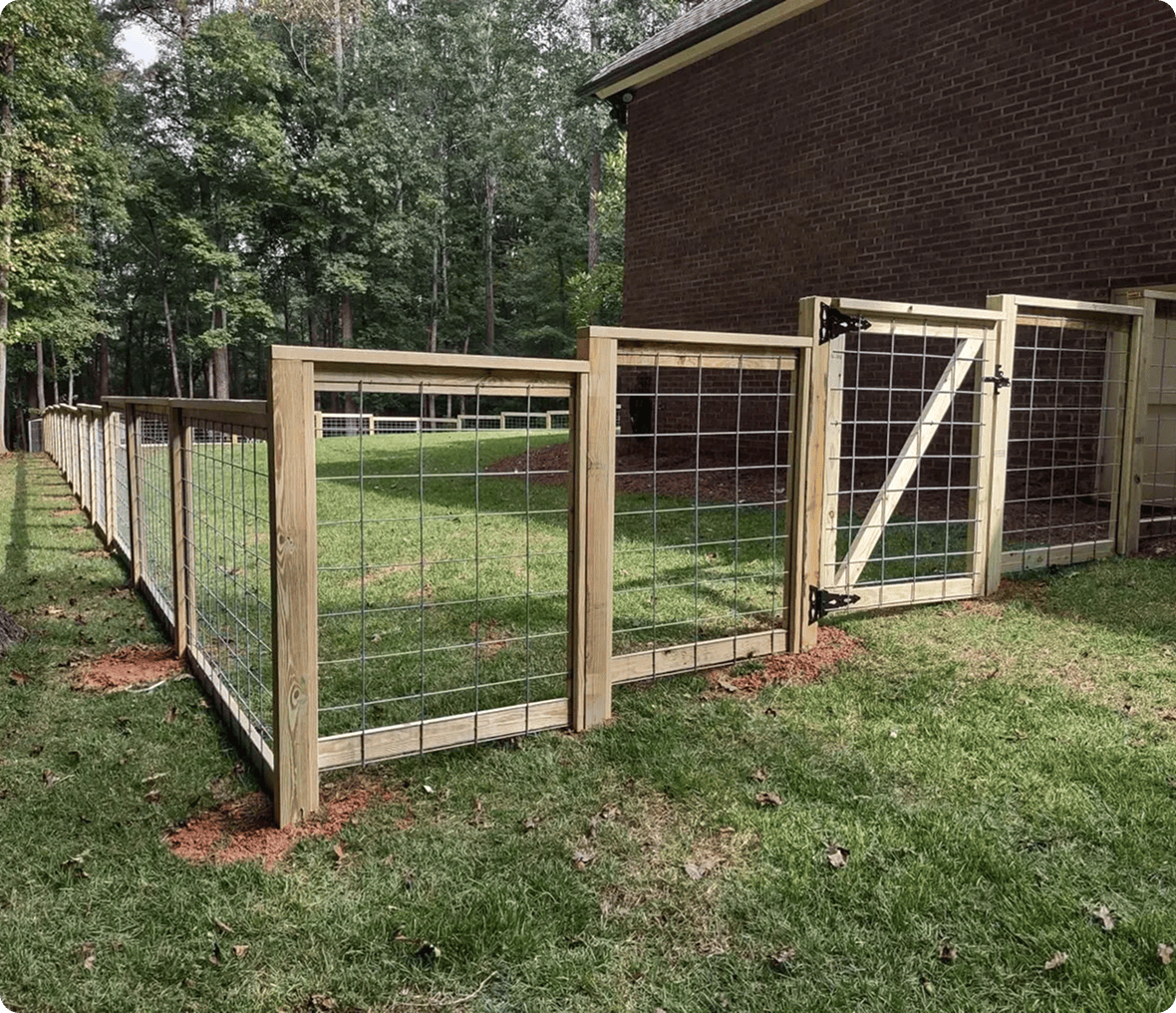 Wooden wire fence beside a brick house.