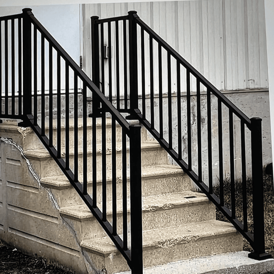 Concrete steps with black metal railings.