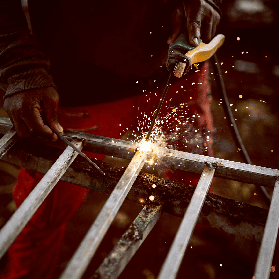 Welder working with metal and sparks flying.
