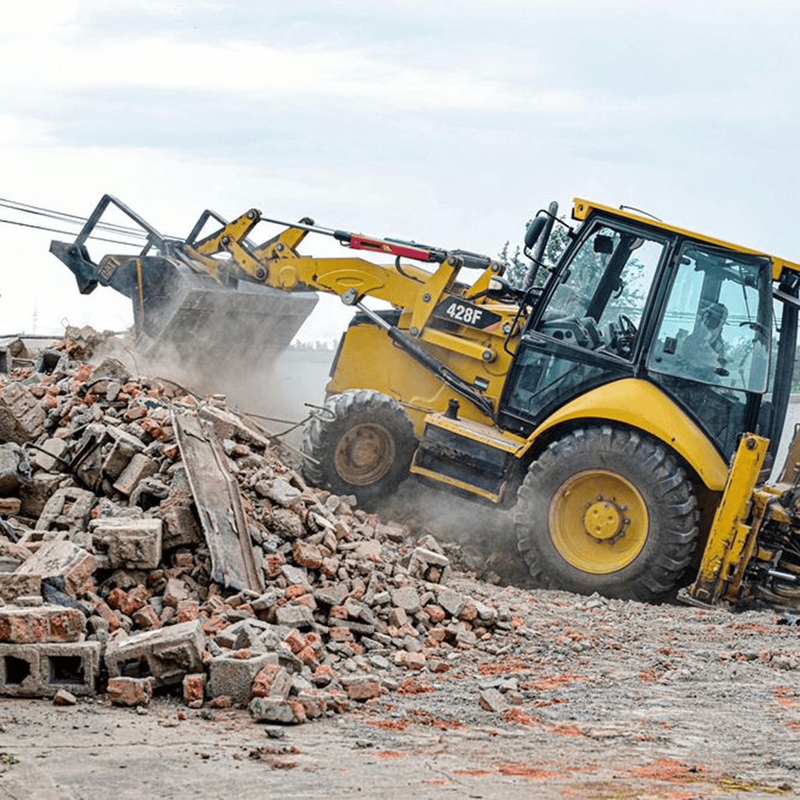 Yellow bulldozer clearing rubble and debris.