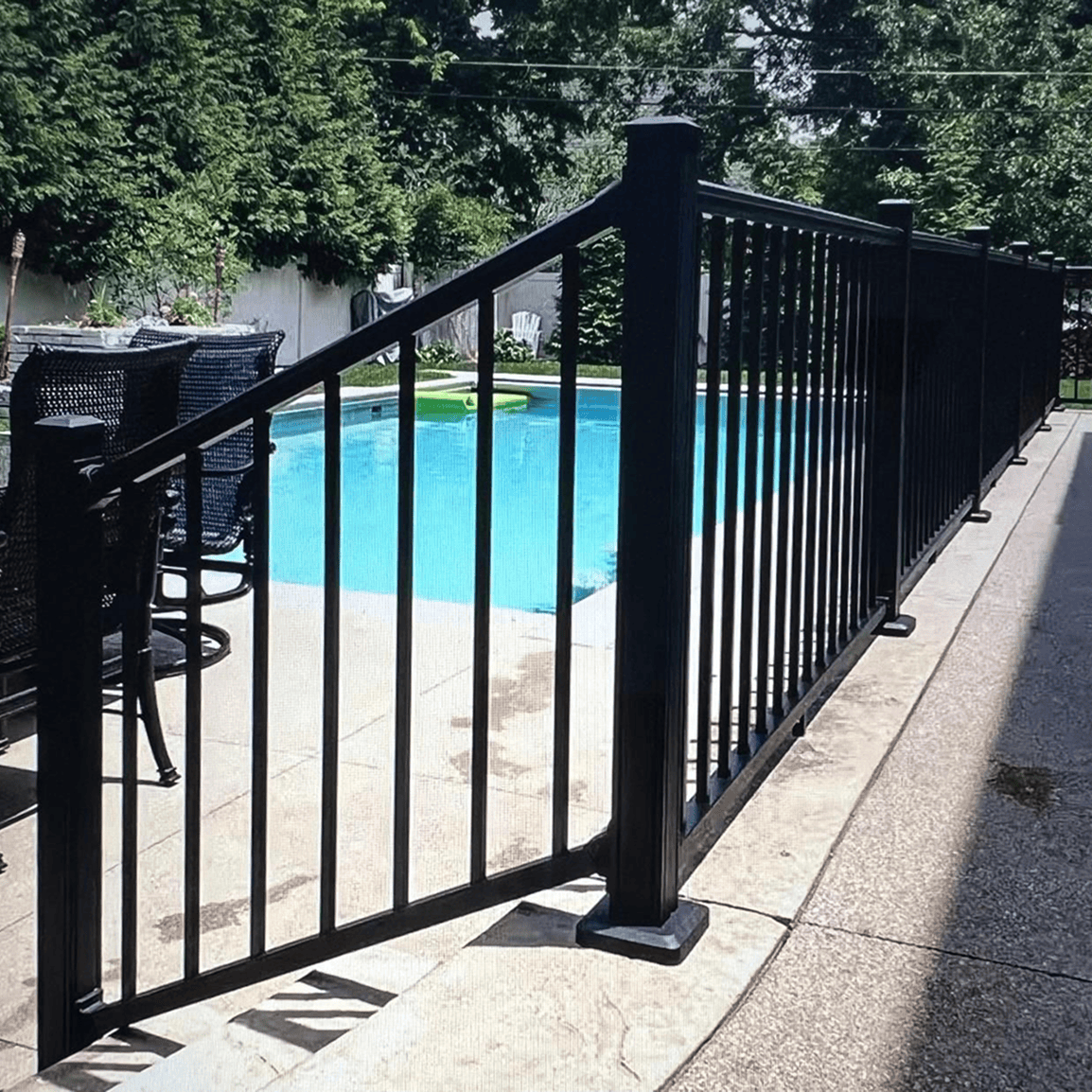 Black fence around an outdoor swimming pool.