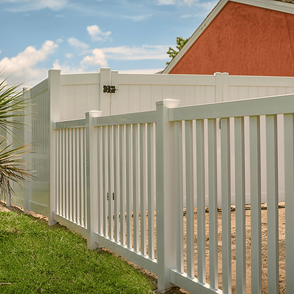 White fence with grass and house background.
