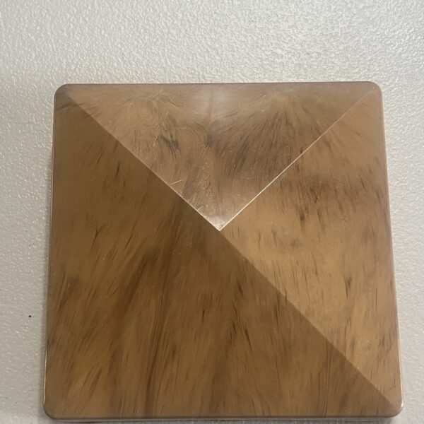 A wooden triangle mounted on a plain white wall, creating a minimalist design element.